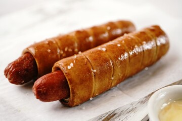 Pretzel hot dogs served with sauce, selective focus - Game day snacks
