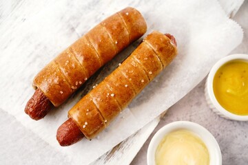 Pretzel hot dogs served with sauce, selective focus - Game day snacks