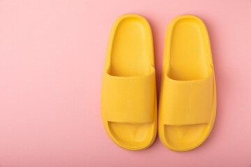 Home slippers on pink paper background, flat lay. Indoor shoes. Place for text. copy space