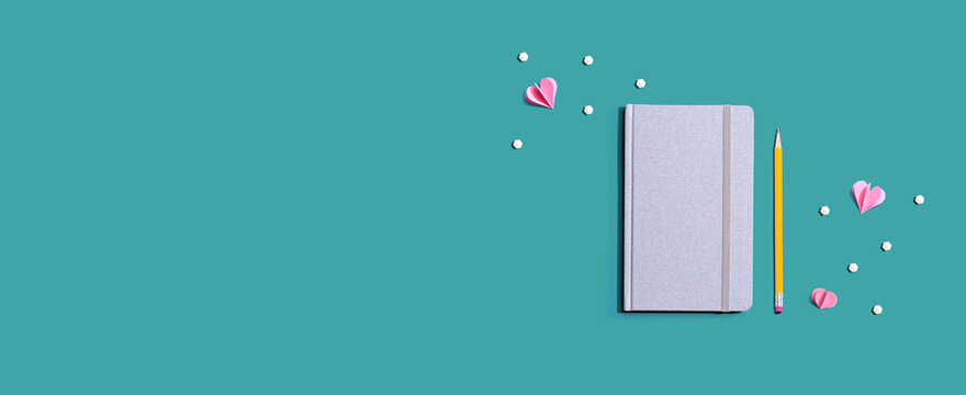 Gray notebook with paper hearts - flat lay