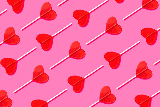 Love retro pattern for Valentine's Day and romantic dates. Candy heart lolipop abstract love relationship concept. Festive pattern of traditional red heart shaped lollipops. flat lay
