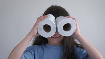 Fun with toilet paper. Happy little girl uses toilet paper instead of binoculars. Children health care concept