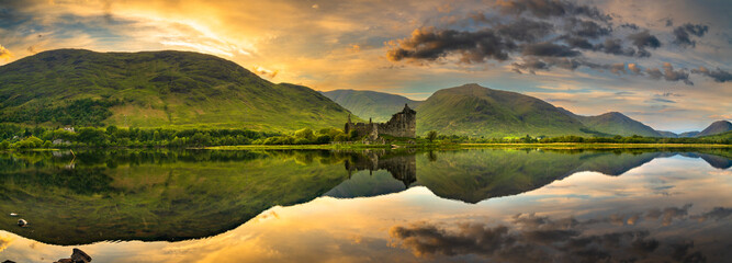 The ruins of Kilchurn castle panorama at sunset on Loch Awe, the longest fresh water loch in...