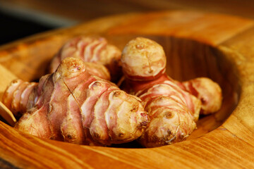 Unpeeled and raw Jerusalem artichokes or Topinambur on a table