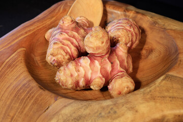 Unpeeled and raw Jerusalem artichokes or Topinambur on a table