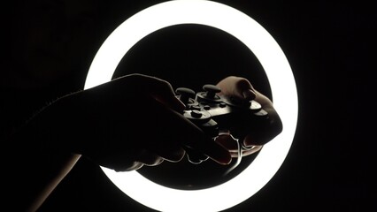 female hands hold a gamepad on a black background. joystick controller for gaming platform close-up. Esports and cybersports concept © Yuliia