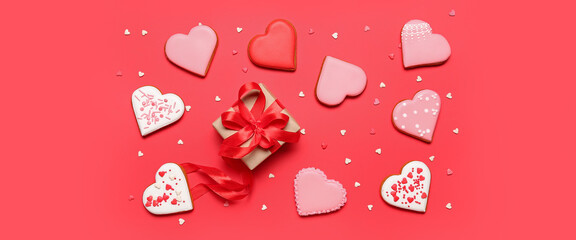 Tasty heart-shaped cookies and gift for Valentine's Day on red background