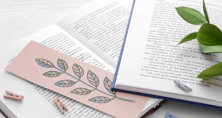 Open books with stylish bookmark on light background, closeup