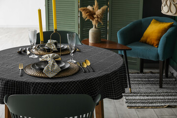 Beautiful table setting with candles in stylish room