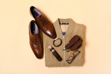 Male jacket, shoes and stylish accessories on beige background