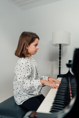 Young girl playing a grand piano