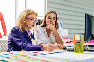 Portrait of young beautiful pretty owner business woman fashion designer stylish sitting and working.Attractive senior woman designer working with colorful fabrics at fashion design workshop studio