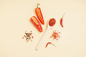 Composition with chipotle chili flakes and fresh jalapeno pepper on color background