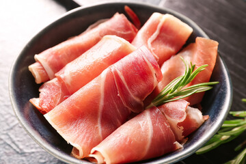 Bowl with rolled slices of tasty ham, closeup