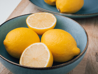 Obraz na płótnie Canvas Half cut and whole lemons in a bowl. Close-up, concept, nobody. 