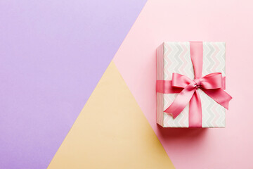 holiday paper present tied pink ribbon bow top view with copy space. Flat lay holiday background. Birthday or christmas present. Christmas gift box concept with copy space