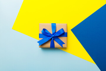 holiday handmade paper present tied blue ribbon bow top view with copy space. Flat lay holiday background. Birthday or christmas present. Christmas gift box concept with copy space