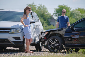 Drivers of smashed vehicles arguing who is guilty in car crash accident on street side. Road safety and insurance concept - obrazy, fototapety, plakaty