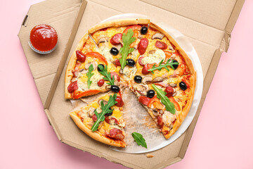 Cardboard box with tasty pizza and sauce on pink background