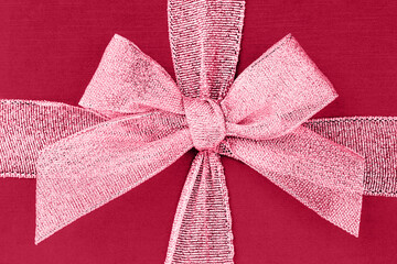 Red viva magenta gift box with ribbon and bow. Top view, background