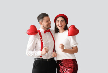 Happy couple in love with balloons on grey background. Valentine's Day celebration