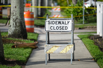 Warning sign that sidewalk is closed at street construction site. Utility work ahead