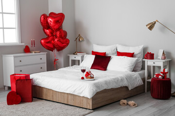 Interior of bedroom decorated for Valentine's Day with balloons and gifts