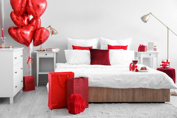 Interior of bedroom decorated for Valentine's Day with engagement ring and gifts