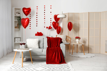 Interior of living room with sofa, tables and red balloons for Valentine's Day