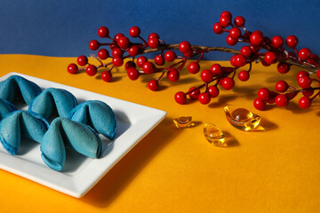 Plate with fortune cookies and Chinese symbols on yellow table, closeup. New Year celebration
