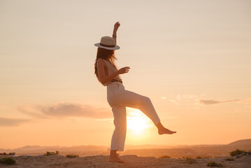 young girl on vacation dances in the sunset