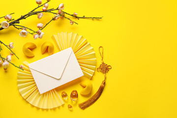 Envelope with fortune cookies, sakura and Chinese symbols on yellow background. New Year celebration