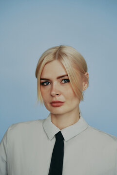 Blonde young woman wearing casual tie shirt serious face
