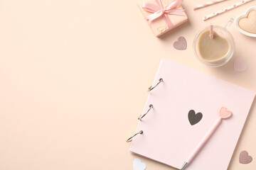 Naklejka premium Feminine desk table with photo album, gift boxes, cup of coffee, heart shaped candles on beige background. Valentines Day holiday celebration concept.