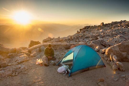 Man camping on summit of Mount Mendel