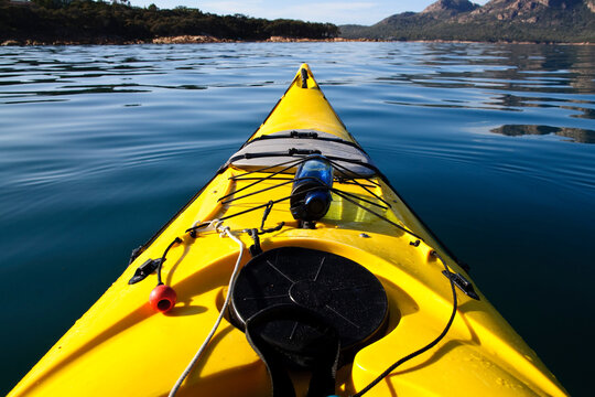 A sea kayak on a calm morning heads into Coles Bay, Freycinet National Park, Tasmania, Australia.