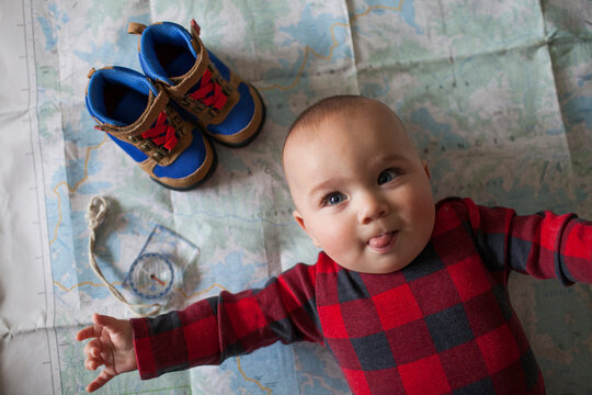 Baby, boots and compass lying down on map