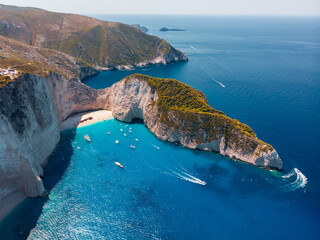 Drone shot of the famous Navagio beach and high limestone walls surrounding the shipwreck at the...
