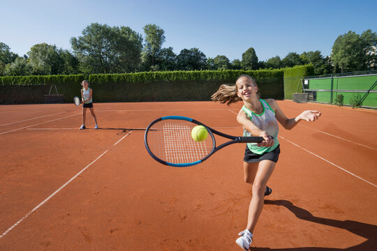 Girls playing tennis on a sunny day, Bavaria, Germany