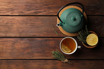 Aromatic herbal tea with thyme and lemon on wooden table, flat lay. Space for text