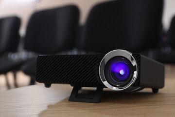 Modern video projector on table in conference room