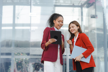 Two asia business women in conversation walking together on city street. Corporate colleagues workmate discussing new project while going to work. business outdoor.