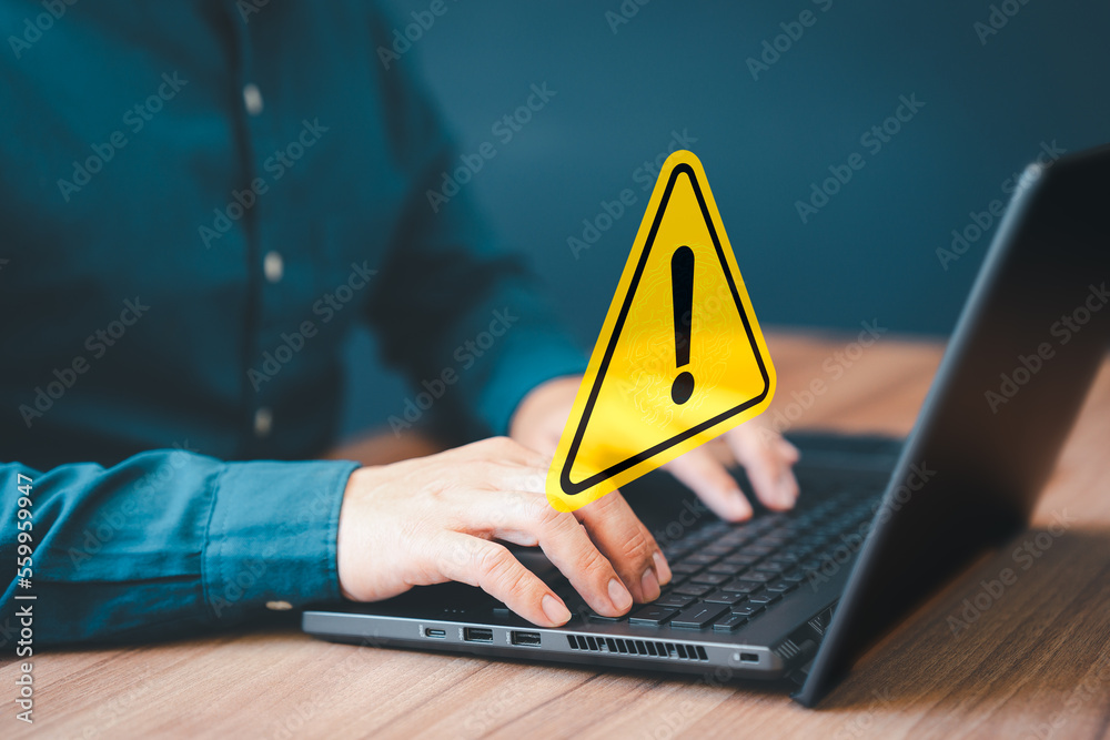 Wall mural adult man using computer laptop with triangle caution warning sign for notification error. computer 