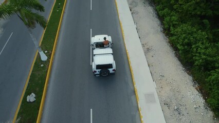 Drone shot view of white cars driving on road in Tulum city, Mexico