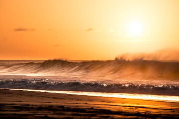 Sol se pondo por trás das ondas e a fumaça da maresia.