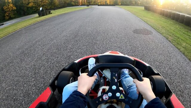 Riding a go kart at sunset point of view on race track
