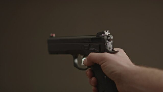 Single hand gently lowering 9mm handgun