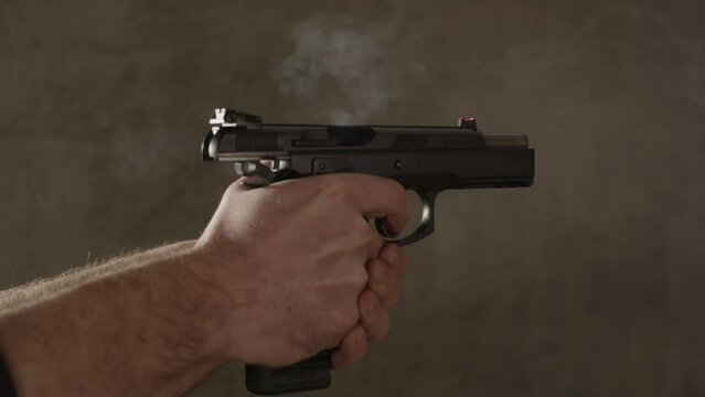 Male hand firing 9mm handgun