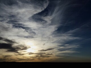 clouds over the sky; blue sky with white wavy and whispy clouds; sunset in west texas