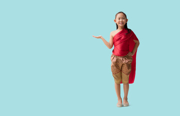 Full body Asian little girl in Thai national costumes with hand holding open palm up blank workspace, isolated on pastel plain light blue background